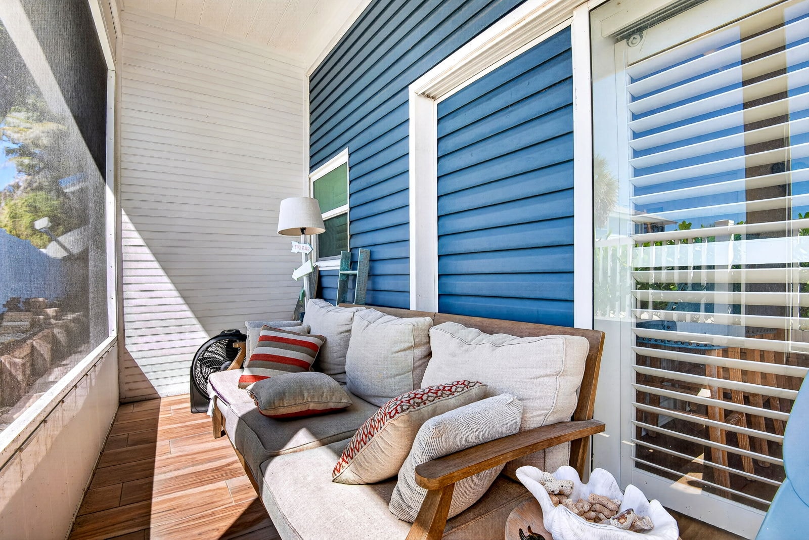 Screened porch daybed seating with louvered glass doors