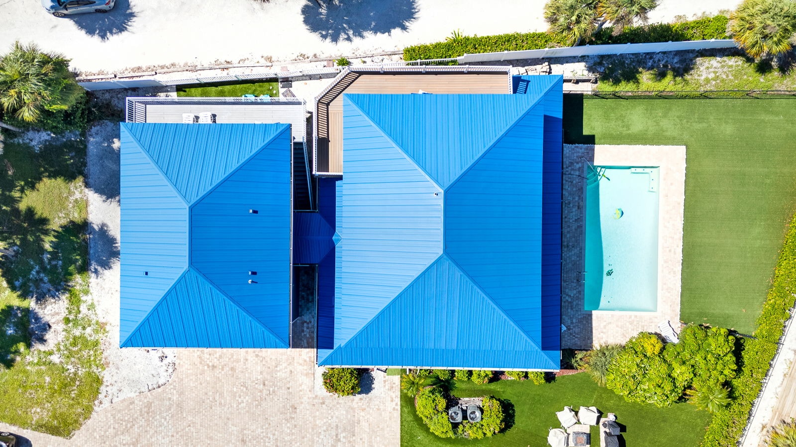 Overhead drone view of the estate’s blue metal roofs and private pool
