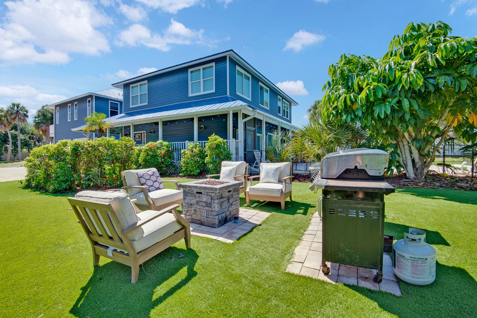 Backyard fire pit lounge with outdoor grill on the estate lawn