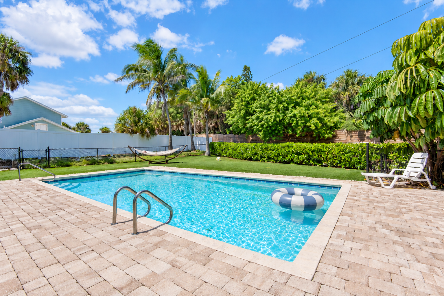 Private pool with hammock, palm trees, and lounge chairs