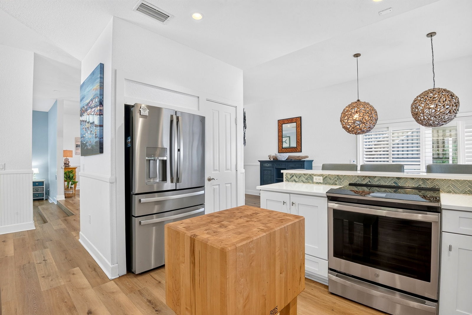 Kitchen with stainless appliances and herringbone tile backsplash